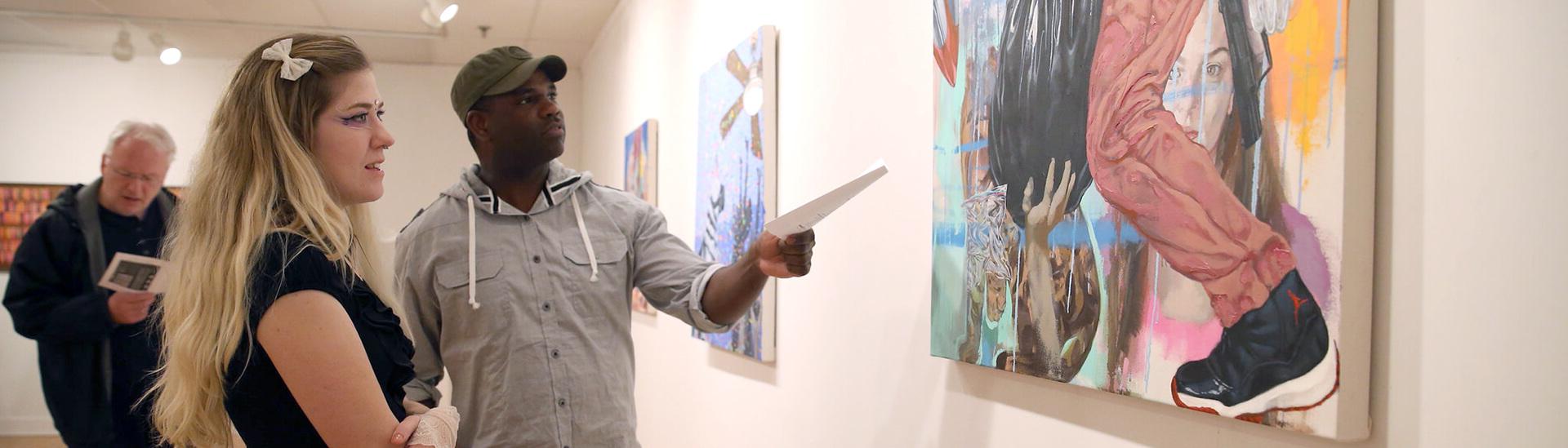 A man and woman observing a painting at The Marling Art Gallery